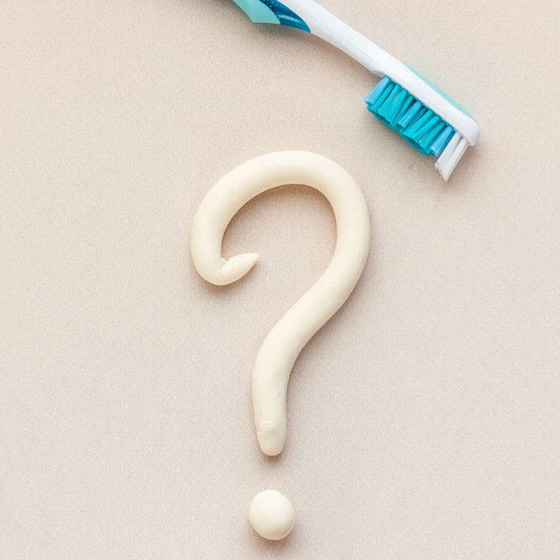 toothpaste question mark with toothbrush